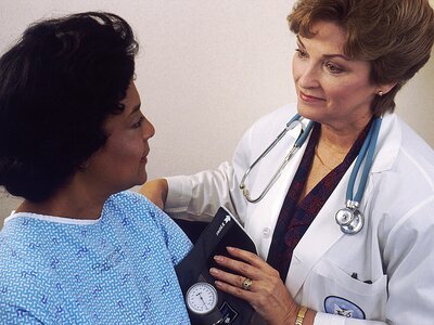 service-1-1 Doctor checking a patient's blood pressure