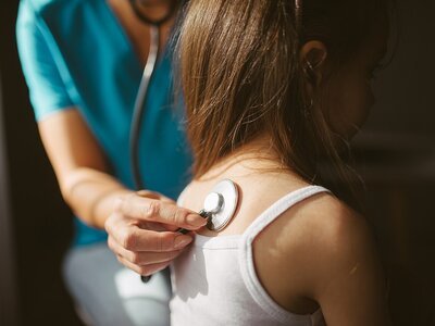 service-1-1 Doctor listening to a patient's chest with a stethoscope